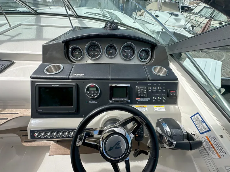 Slide: The Image of Cockpit of 2015 Sea Ray 350 Sundancer with steering wheel and control panel. - 10