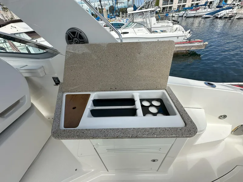 Slide: The Image of Outdoor kitchenette on 2015 Sea Ray 350 Sundancer yacht, featuring a sink and storage. - 13