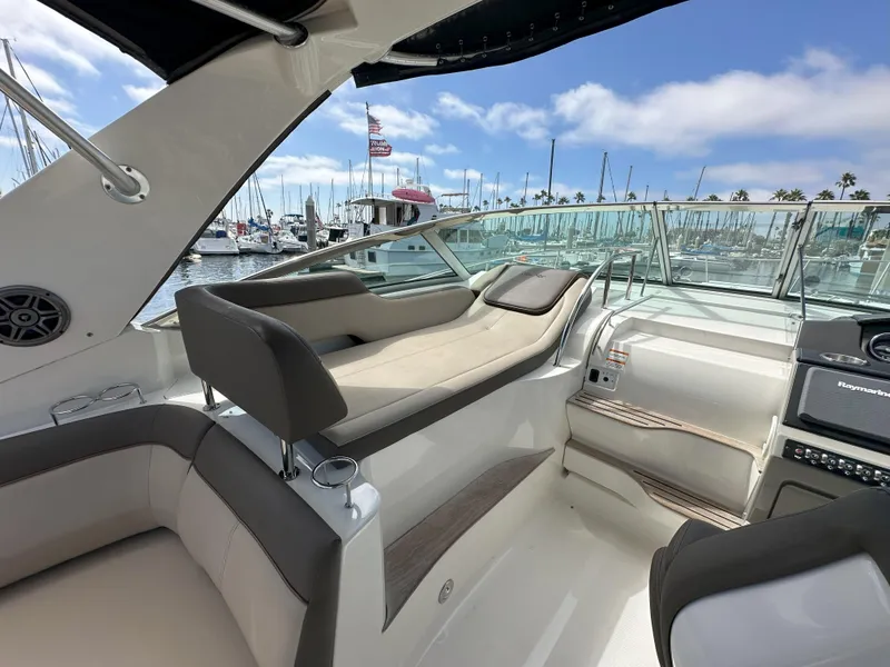 Slide: The Image of 2015 Sea Ray 350 Sundancer interior with luxurious seating and marina view. - 14