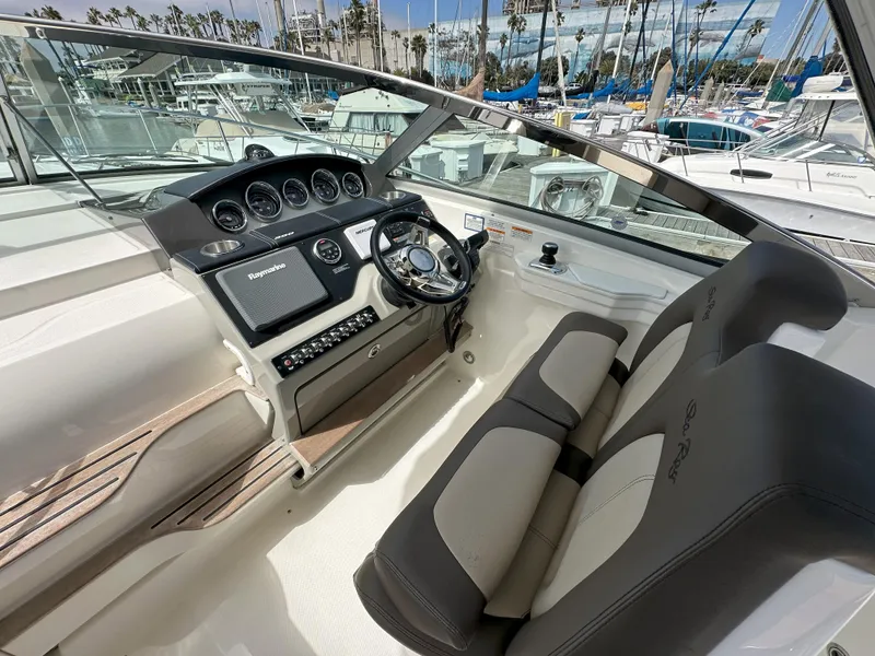 Slide: The Image of 2015 Sea Ray 350 Sundancer helm with modern controls and comfortable seating at marina. - 15
