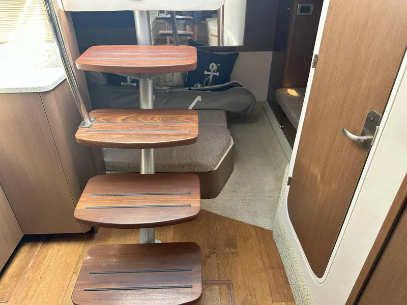 Slide: The Image of Interior of 2015 Sea Ray 350 Sundancer with wooden steps and cozy seating area. - 24