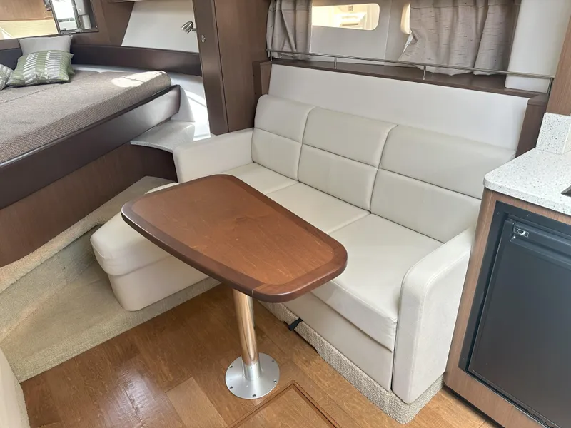 Slide: The Image of Interior of 2015 Sea Ray 350 Sundancer with sofa, table, and bed. - 25