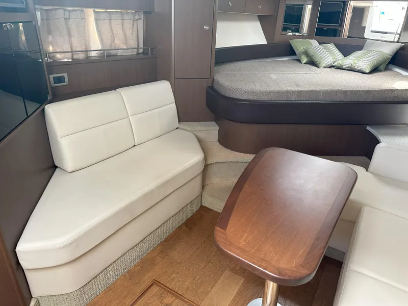 Slide: The Image of Interior of 2015 Sea Ray 350 Sundancer with seating, table, and bed. - 26