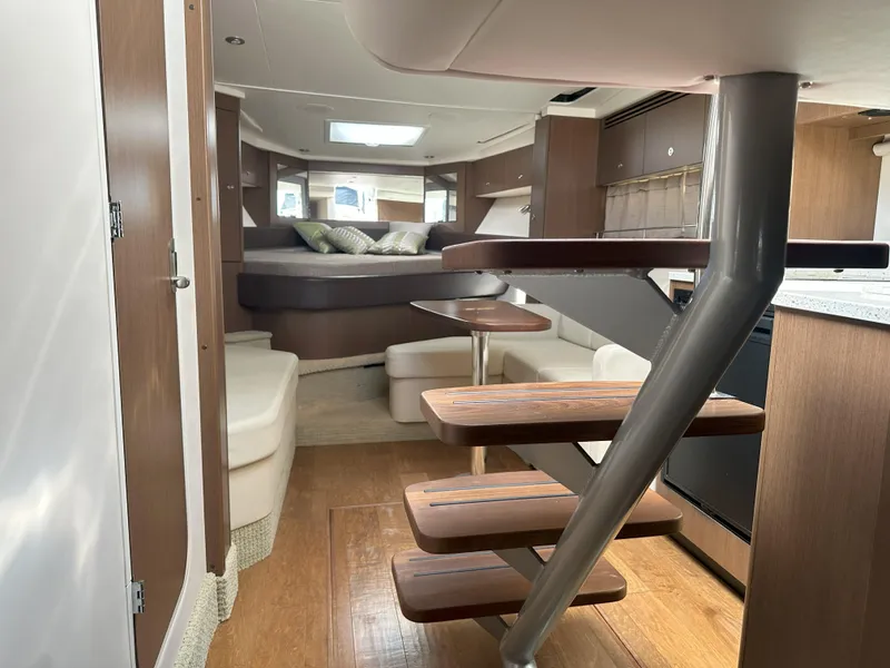 Slide: The Image of Interior of 2015 Sea Ray 350 Sundancer yacht with modern wood finishes and cozy seating. - 27