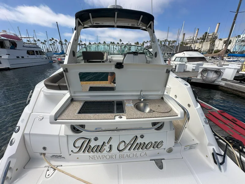 Slide: The Image of 2015 Sea Ray 350 Sundancer yacht with outdoor kitchenette, docked in Newport Beach marina. - 4
