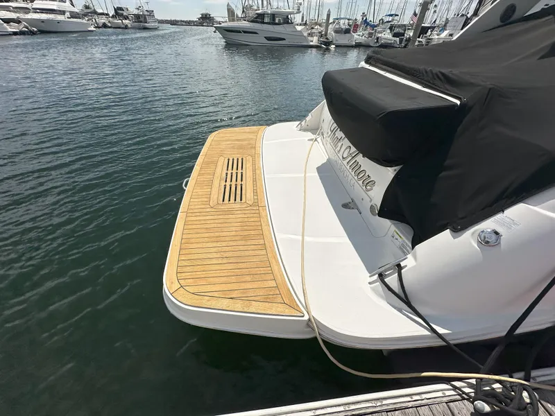 Slide: The Image of 2015 Sea Ray 350 Sundancer docked, featuring a wooden swim platform. - 7