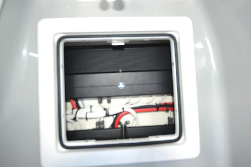 Slide: The Image of 2024 Costa Custom Boats 264HC interior compartment with visible wiring and components. - 16