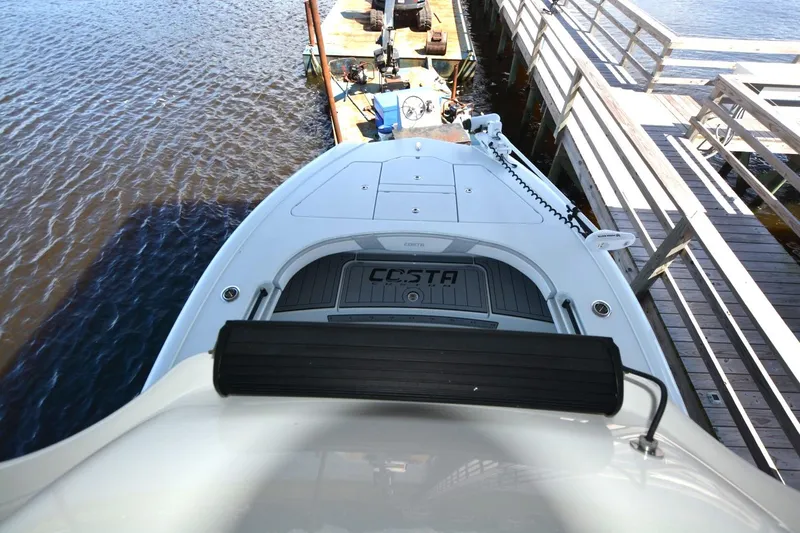 Slide: The Image of 2024 Costa Custom Boats 264HC docked, showcasing sleek design and spacious deck. - 24