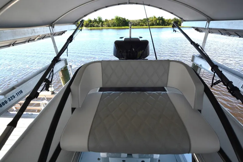 Slide: The Image of 2024 Costa Custom Boats 264HC interior with cushioned seating, under canopy, overlooking water. - 25