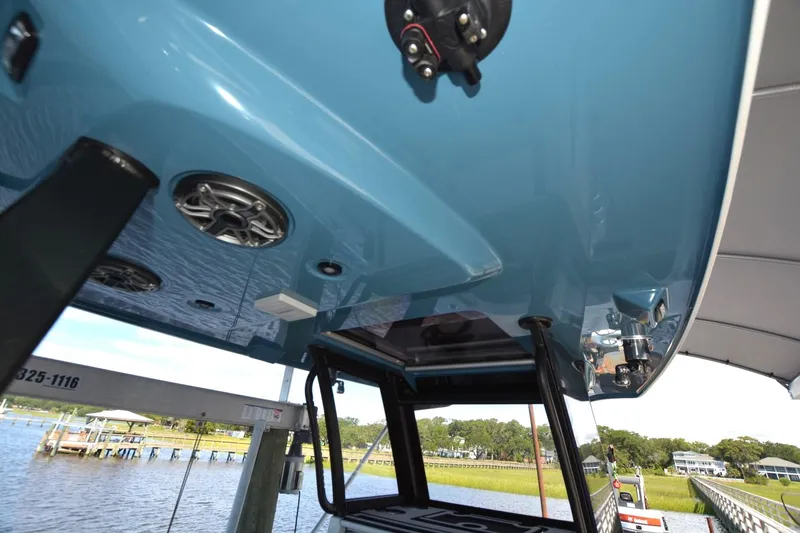 Slide: The Image of 2024 Costa Custom Boats 264HC, blue hull, docked with visible speakers and equipment. - 31