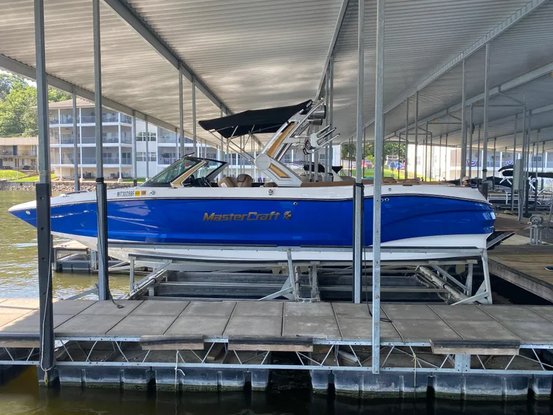 Slide: The Image of 2022 MasterCraft X26 boat docked under covered marina. - 12