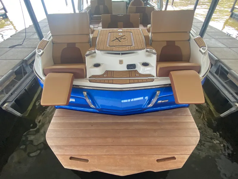 Slide: The Image of 2022 MasterCraft X26 boat with luxurious seating and swim platform in dock. - 13