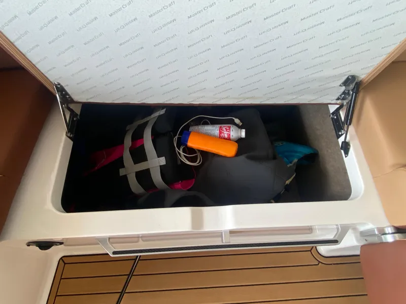 Slide: The Image of Storage compartment in 2022 MasterCraft X26 boat with life jacket and safety gear. - 26