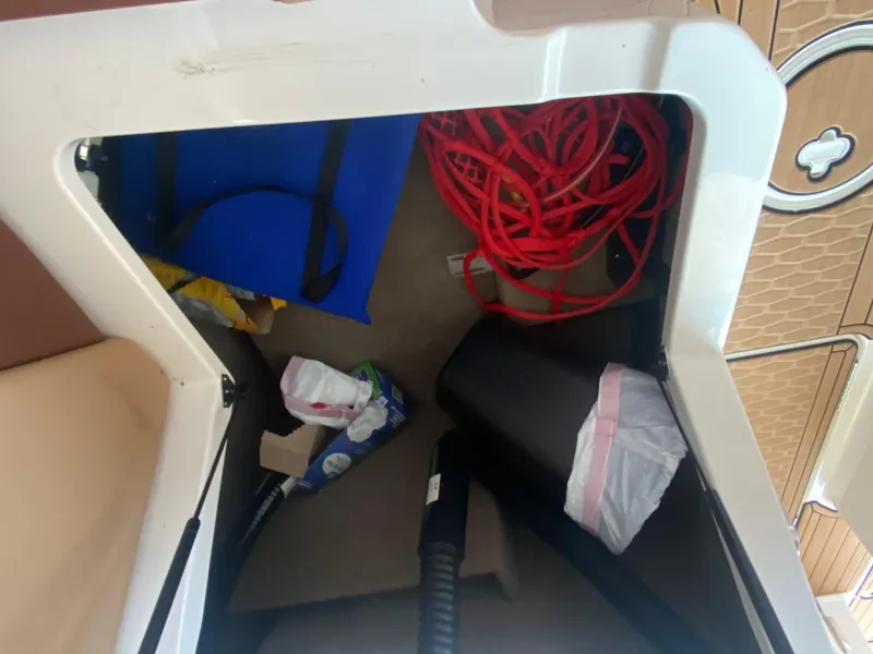 Slide: The Image of Storage compartment in 2022 MasterCraft X26 boat with various items. - 27