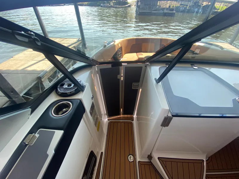 Slide: The Image of 2022 MasterCraft X26 boat interior with wood flooring and lake view. - 36
