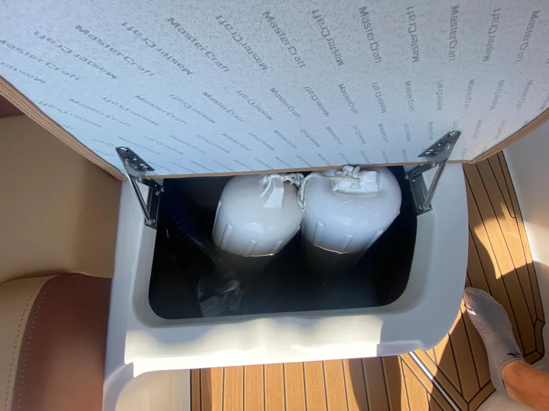 Slide: The Image of Open storage compartment in 2022 MasterCraft X26 boat with fenders inside. - 39