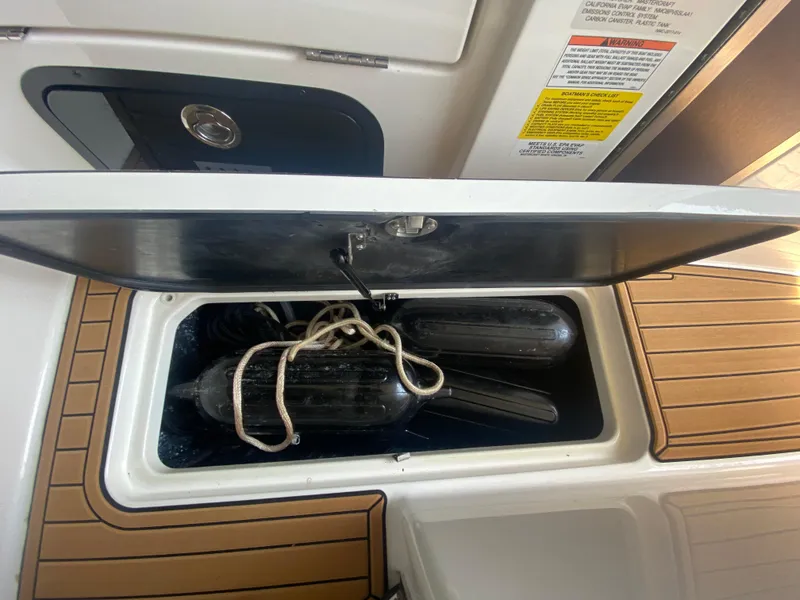 Slide: The Image of Open storage compartment on 2022 MasterCraft X26 boat with fenders and rope. - 42