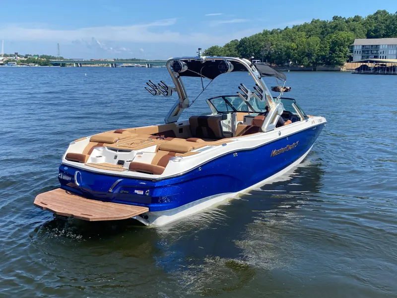 Slide: The Image of 2022 MasterCraft X26 boat on a lake, featuring sleek design and luxurious seating. - 5