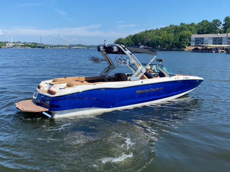 Slide: The Image of 2022 MasterCraft X26 boat cruising on a sunny lake. - 6