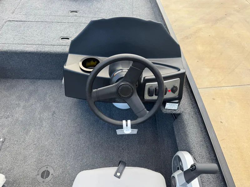 Slide: The Image of Steering console of 2025 Crestliner 1700 Storm boat with controls and gray carpet. - 5