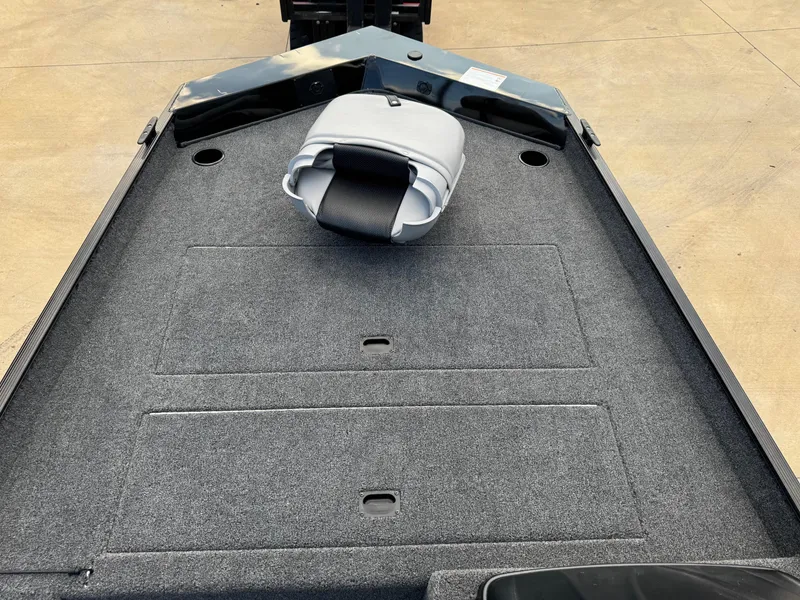 Slide: The Image of 2025 Crestliner 1700 Storm boat deck with gray carpet and folded seat. - 7