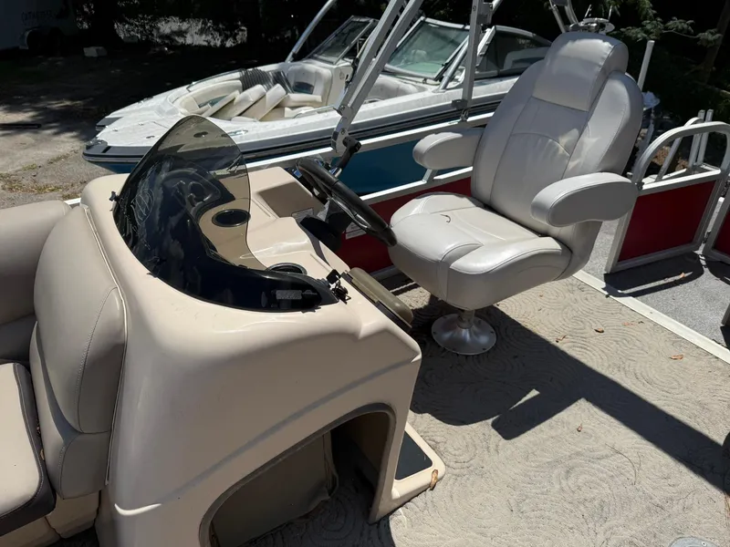 Slide: The Image of 2015 Sun Tracker Party Barge 20 DLX interior with captain's chair and console. - 2