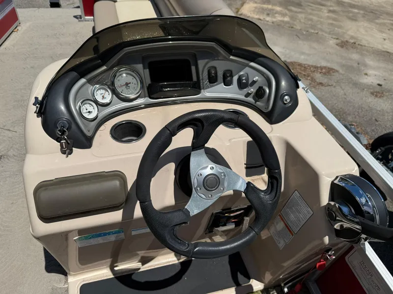 Slide: The Image of 2015 Sun Tracker Party Barge 20 DLX steering console with gauges and controls. - 3