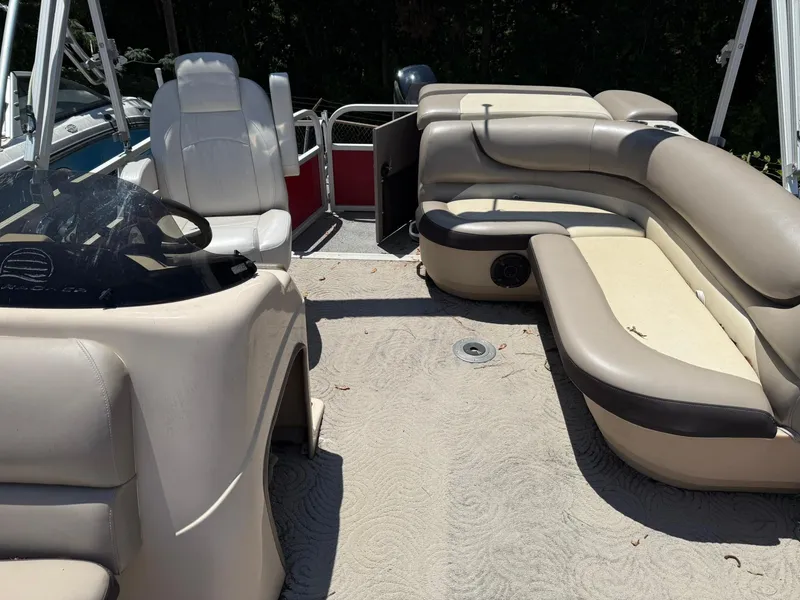Slide: The Image of 2015 Sun Tracker Party Barge 20 DLX interior with beige seating and steering console. - 5