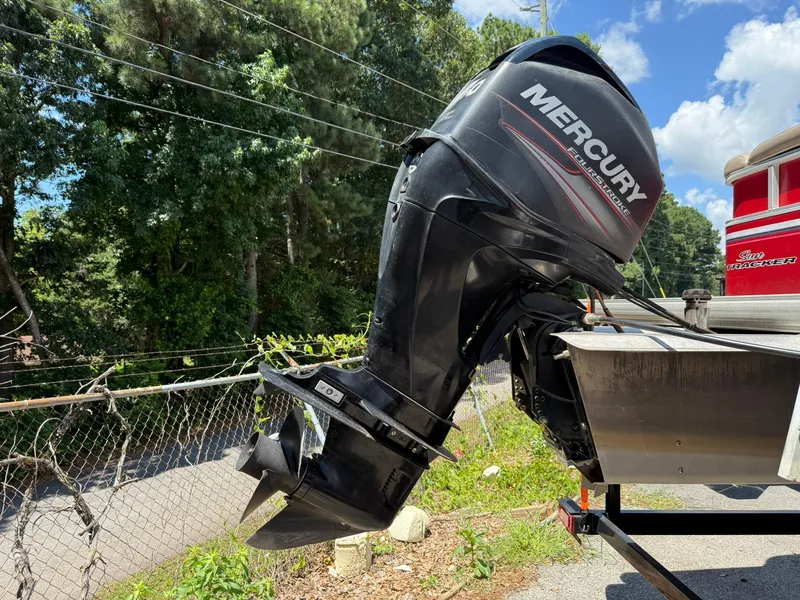 Slide: The Image of Outboard motor on 2015 Sun Tracker Party Barge 20 DLX, parked near trees. - 6