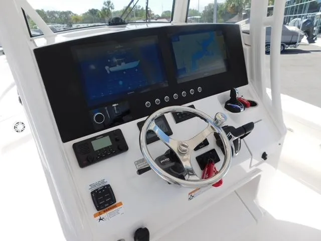 Slide: The Image of 2024 Regulator 30XO boat dashboard with dual screens and steering wheel. - 14