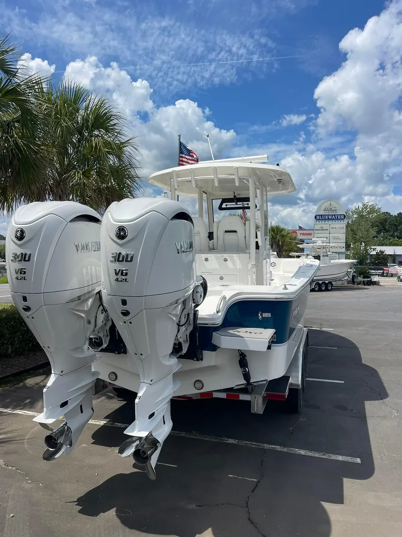 Slide: The Image of 2024 Regulator 30XO boat with dual Yamaha 300 V6 engines, parked outdoors. - 2
