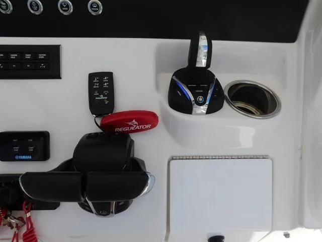 Slide: The Image of 2024 Regulator 30XO boat control panel with Yamaha throttle and cup holder. - 25