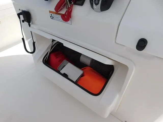 Slide: The Image of 2024 Regulator 30XO boat storage compartment with safety gear and accessories. - 30