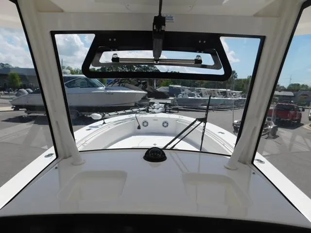 Slide: The Image of 2024 Regulator 30XO boat interior view with windshield and docked boats in background. - 33