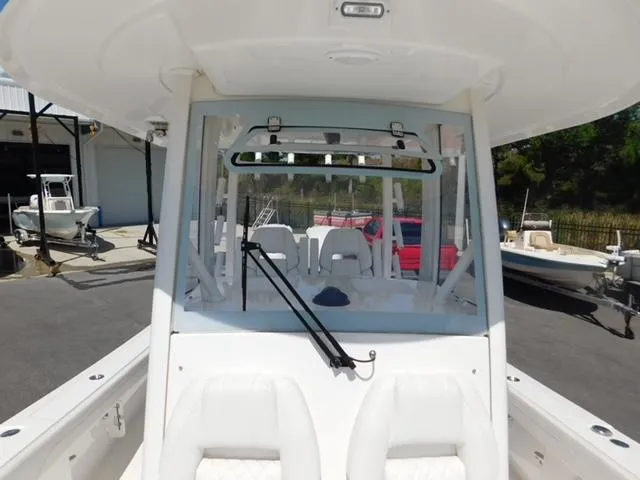 Slide: The Image of 2024 Regulator 30XO boat with white seating and windshield, docked outdoors. - 43