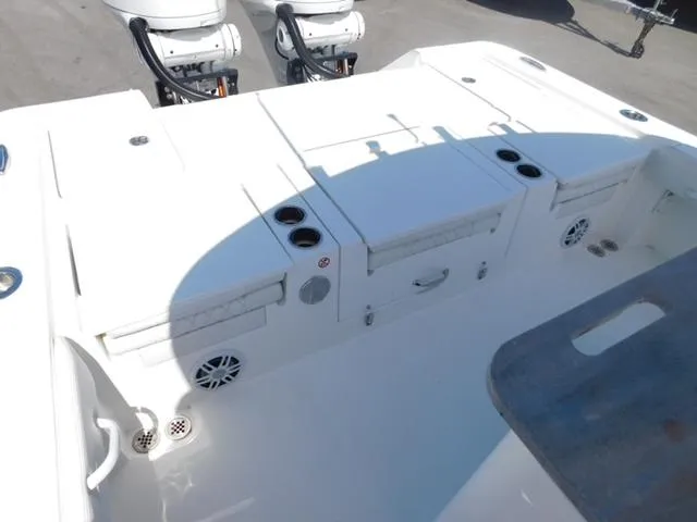 Slide: The Image of 2024 Regulator 30XO boat deck with storage compartments and twin outboard motors. - 47