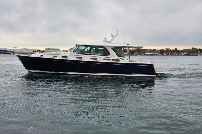 Slide: The Image of Luxurious cabin interior of 2027 Sabre 51 Salon Express yacht, featuring cozy bedding and wooden finishes. - 19