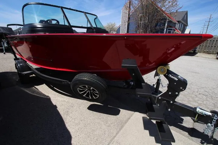 Slide: The Image of 2025 Lund 1875 Impact XS Sport boat on trailer, red exterior, parked outdoors. - 3