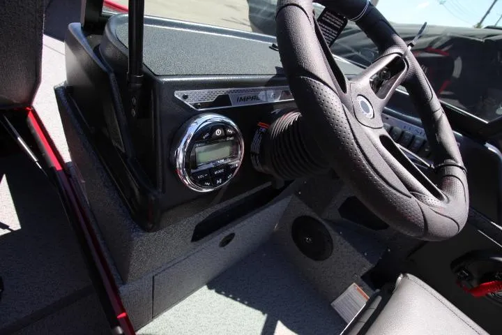 Slide: The Image of 2025 Lund 1875 Impact XS Sport boat dashboard with steering wheel and control panel. - 9