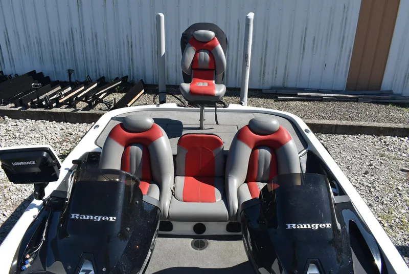 Slide: The Image of 2011 Ranger Z521 Comanche boat with red and gray seating, parked outdoors. - 12