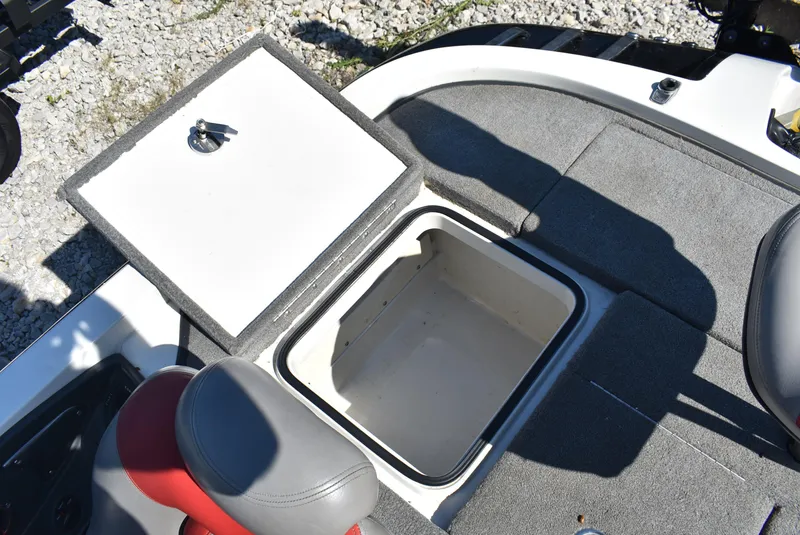 Slide: The Image of 2011 Ranger Z521 Comanche boat storage compartment with open lid on carpeted deck. - 13