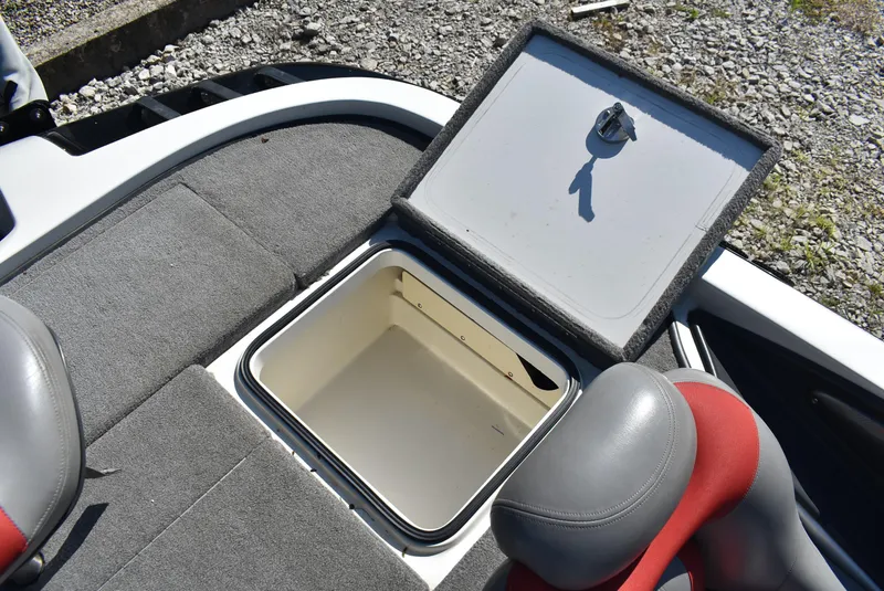 Slide: The Image of 2011 Ranger Z521 Comanche boat storage compartment with open lid, gray and red seating. - 15