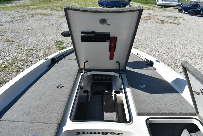 Slide: The Image of 2011 Ranger Z521 Comanche boat with open storage compartment on a gravel lot. - 18