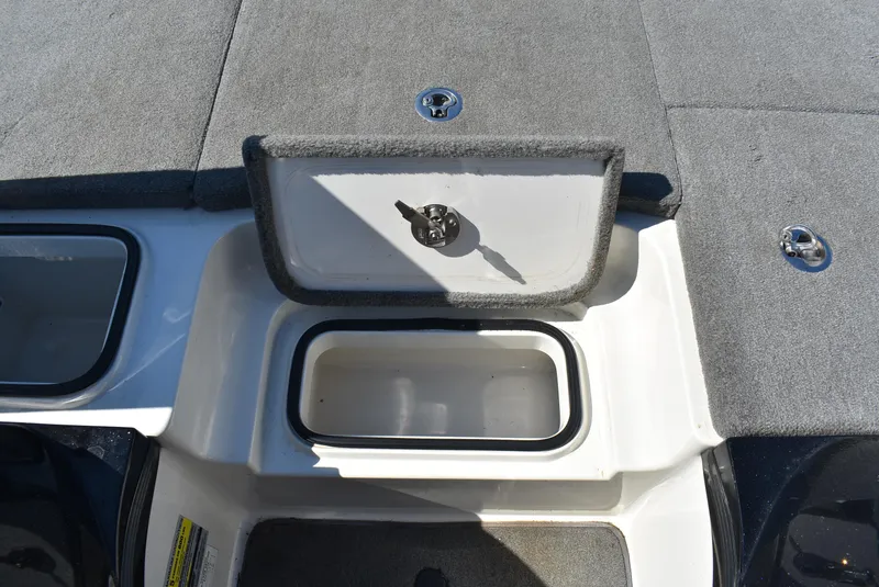 Slide: The Image of 2011 Ranger Z521 Comanche boat storage compartment with open lid and gray carpeted surface. - 19