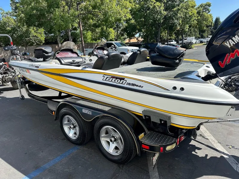 Slide: The Image of 2004 Triton Tr-20XDC boat on trailer, parked outdoors, featuring sleek design and Yamaha engine. - 10