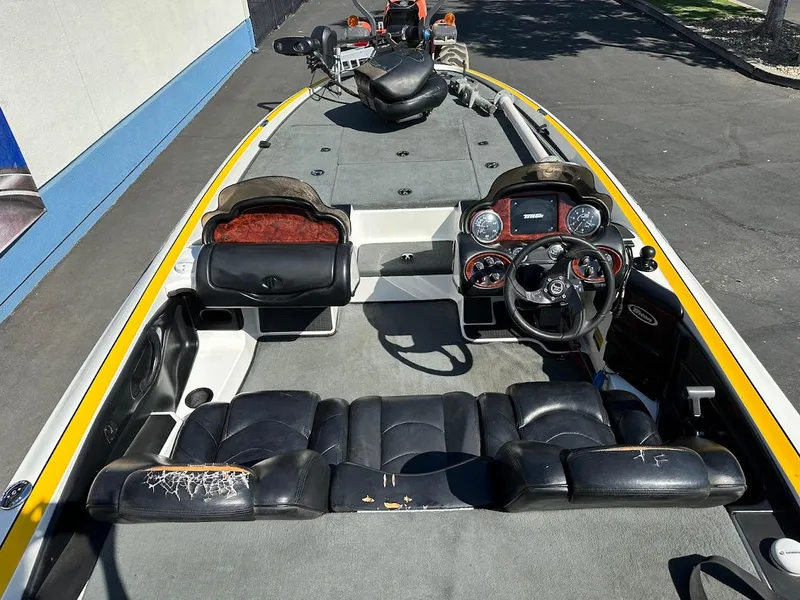 Slide: The Image of 2004 Triton Tr-20XDC boat interior with steering wheel, dashboard, and seating. - 12