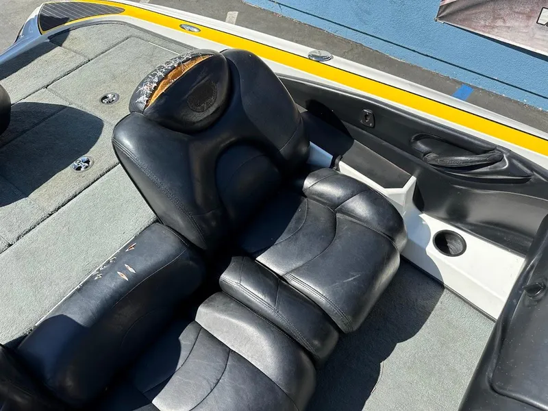 Slide: The Image of 2004 Triton Tr-20XDC boat interior with worn black leather seats and gray carpet. - 14