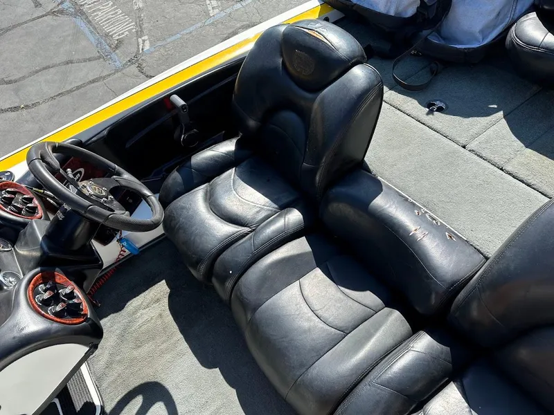 Slide: The Image of 2004 Triton Tr-20XDC boat interior with black leather seats and steering wheel. - 16