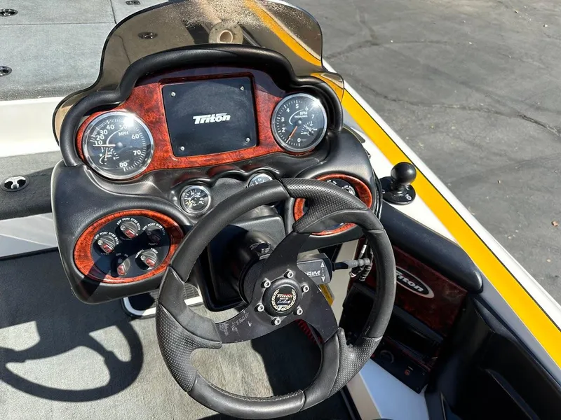 Slide: The Image of 2004 Triton Tr-20XDC boat dashboard with steering wheel and gauges. - 17