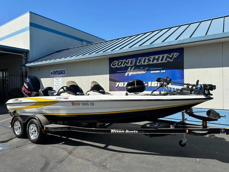 Slide: The Image of 2004 Triton Tr-20XDC boat on trailer outside a fishing store. - 2